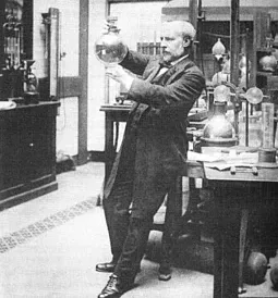 A historical black-and-white photograph of a scientist examining a glass flask in a laboratory.